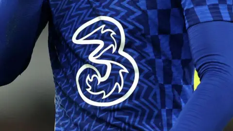 Getty Images A detailed view of the Three logo is seen on the shirt of a Chelsea player during the Premier League match in 2022